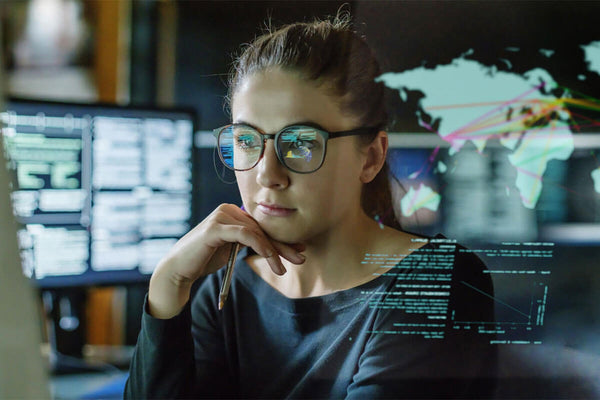 Female worked with glasses with computers in background